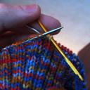 take second knit stitch and first purl stitch off knitting needle